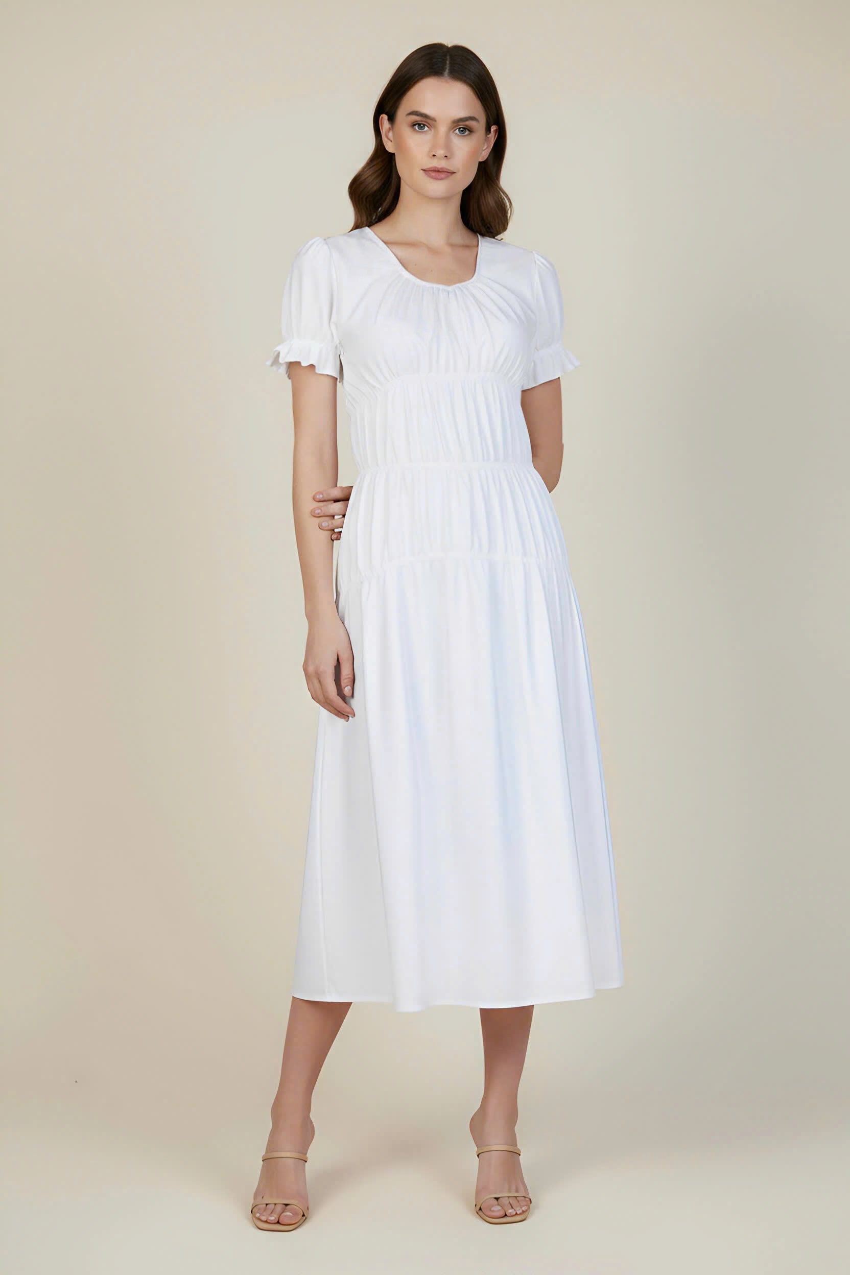 Woman wearing a white dress against a plain background