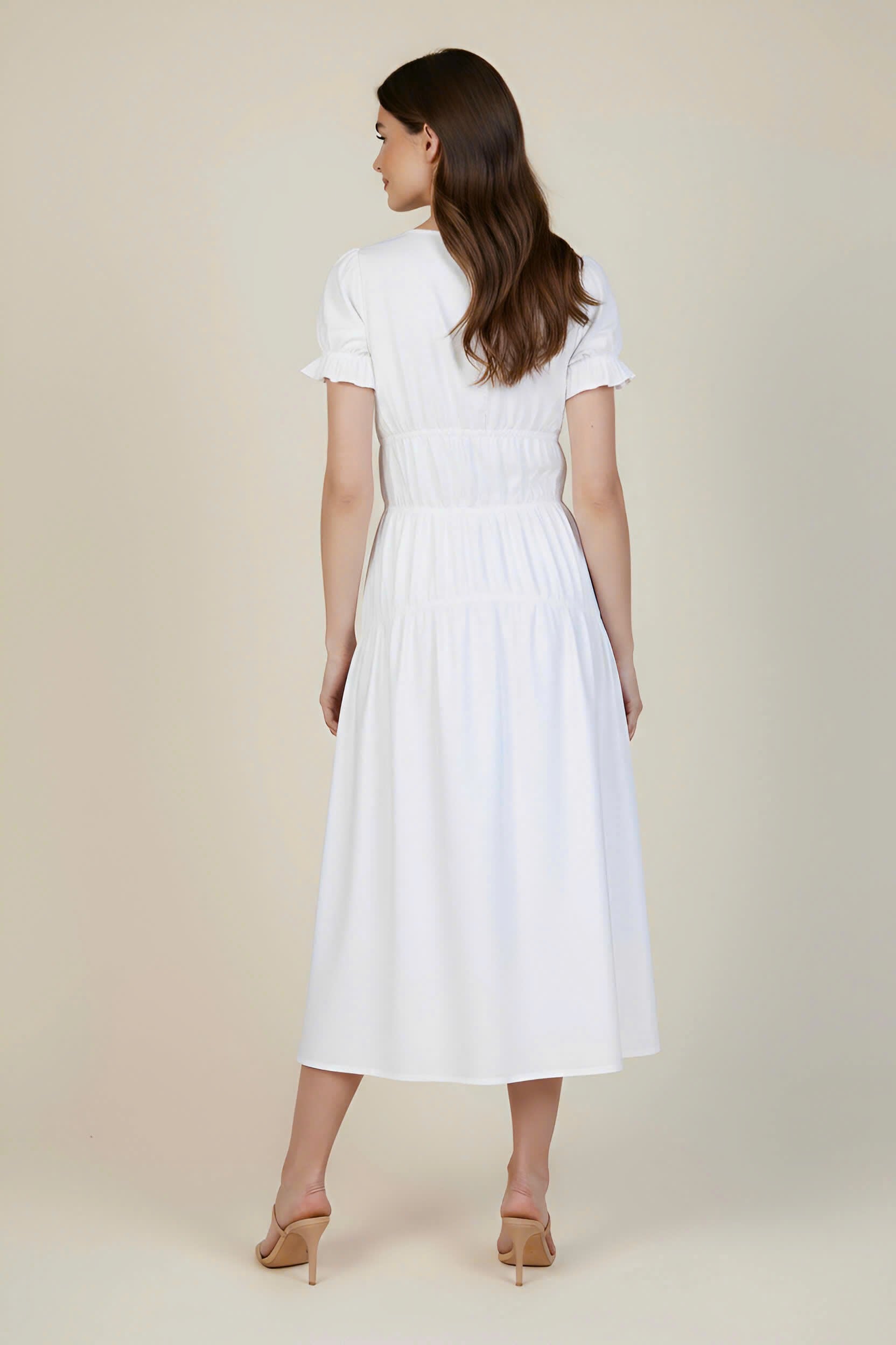 Woman wearing a white dress on a beige background