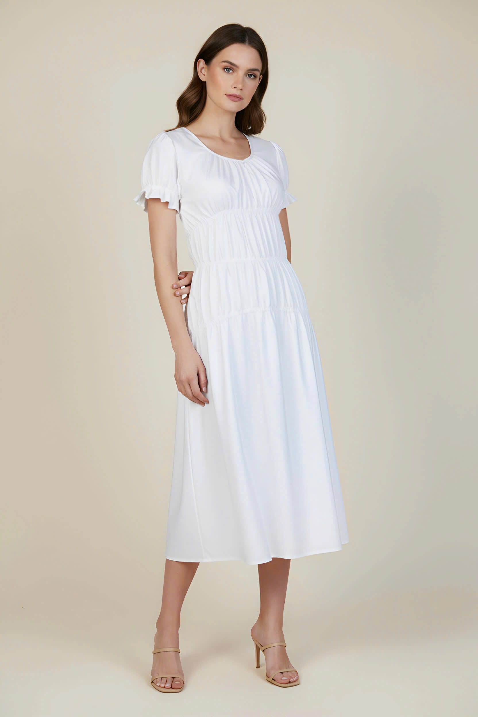 Woman wearing a white dress on a beige background