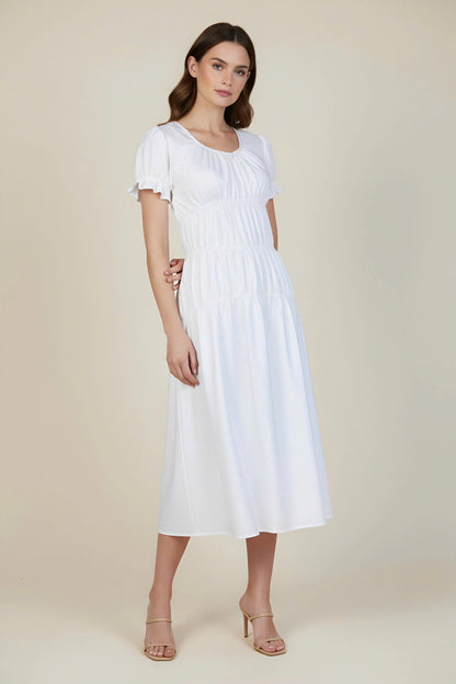 Woman wearing a white dress on a beige background