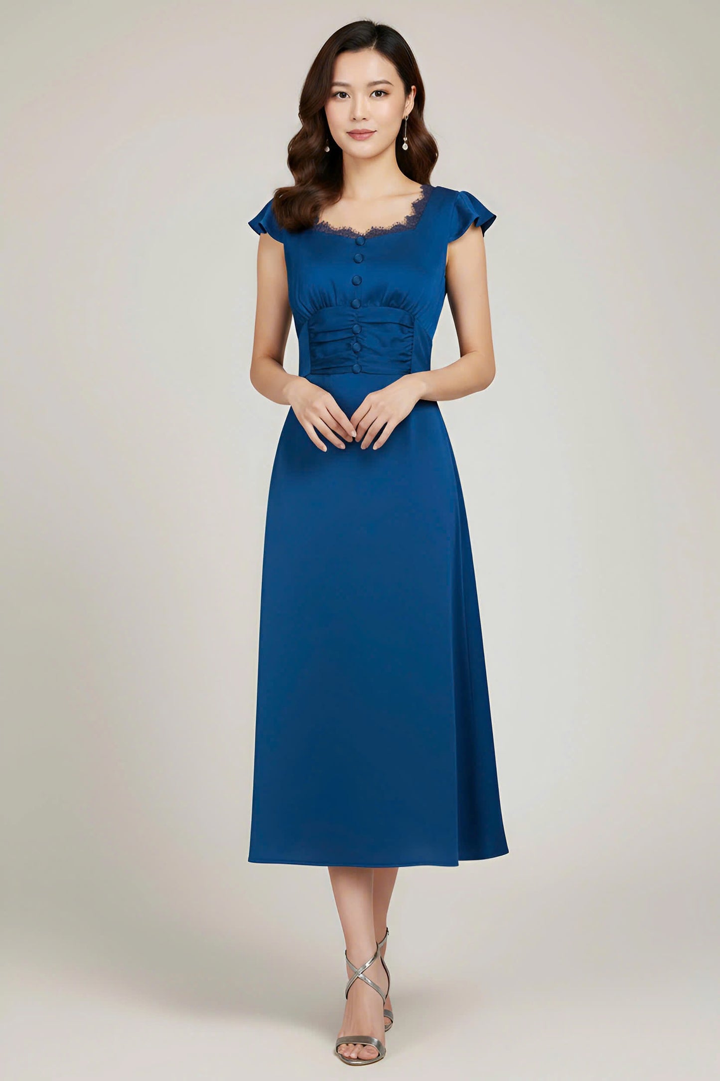 Woman wearing a blue dress against a plain background