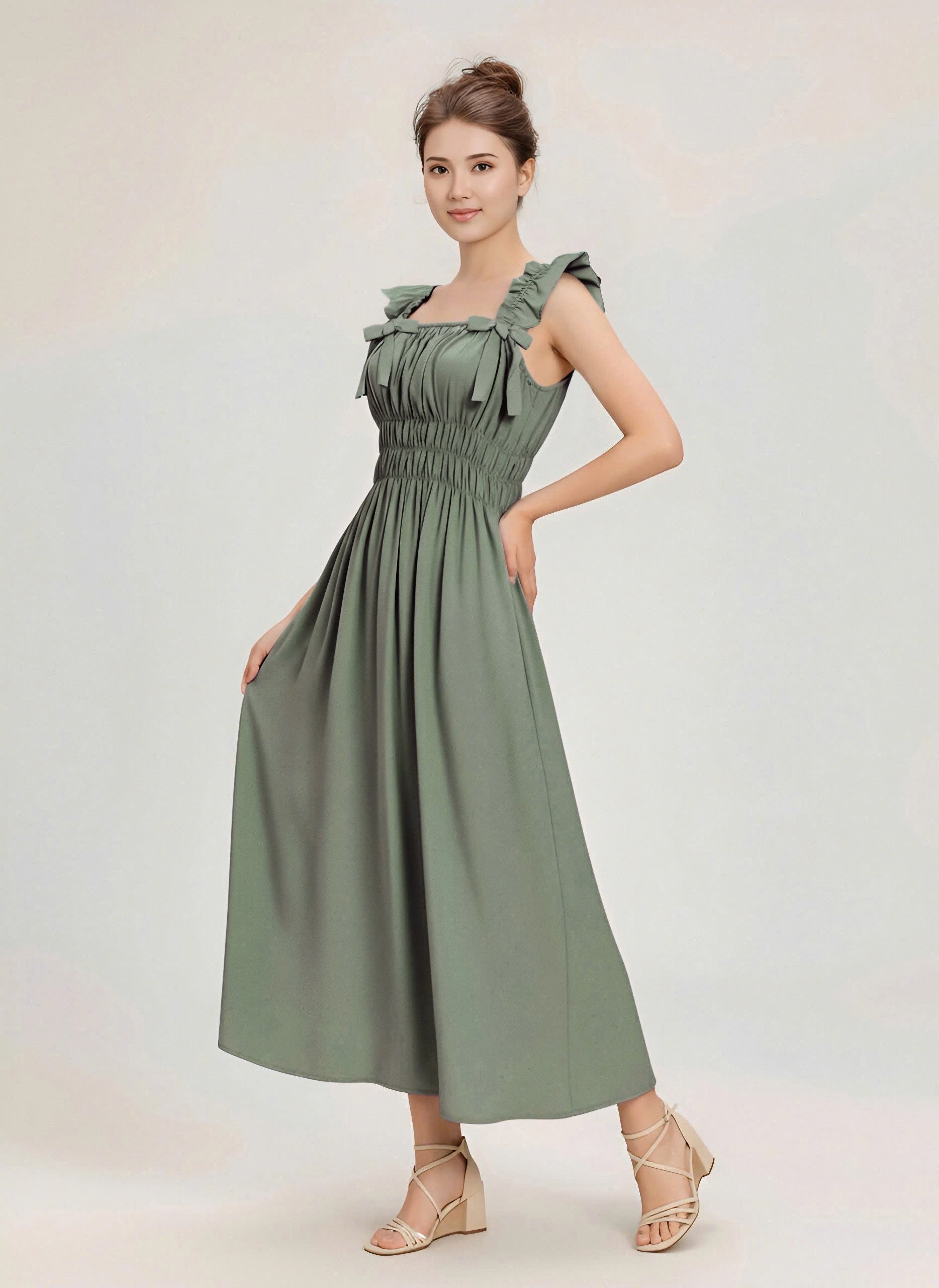 Woman wearing a green dress against a plain background with unique pose